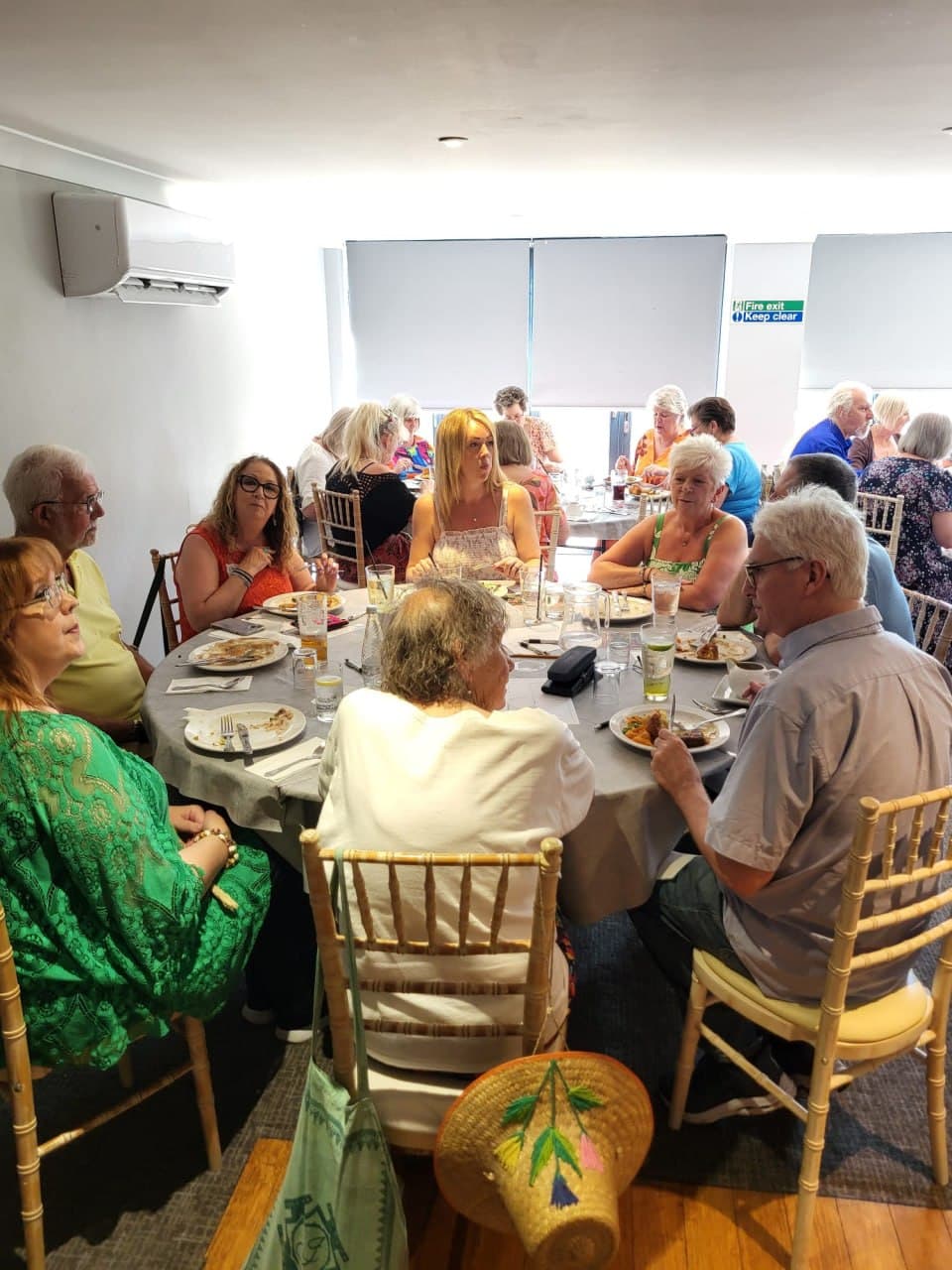 Friends chatting and smiling over lunch at a Lightworkers Lunch